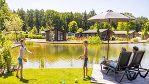 Un cadre idyllique au bord du lac, avec une terrasse en bois, des chaises longues et un pavillon.