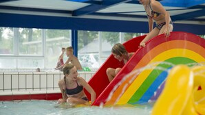 A pool area with a water slide and other children playing. - Cozy Farm Stay for Groups (Zuna)