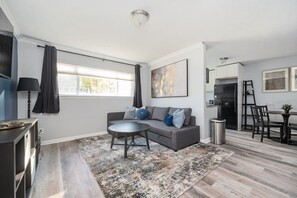 A modern living room with a grey sofa, a round coffee table, and a patterned rug. - [REFRESHED] Quiet & Quaint 1BR 5min to airport and 15mins to downtown (College Park)