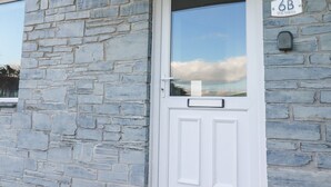 A stone wall with a white door and a mailbox. - 6B The Mews (Padstow)