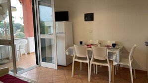 Un comedor con una mesa, sillas y un refrigerador.