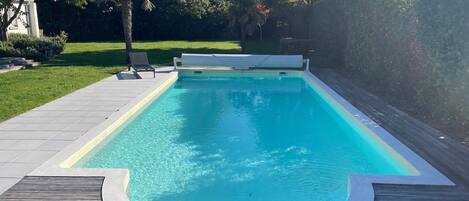 Een verwarmd zwembad en ligstoelen