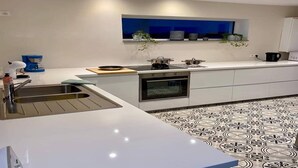 A modern kitchen with a built-in oven, a sink, and a window above the countertop. - Peaceful Garden Home in Modave (Modave)
