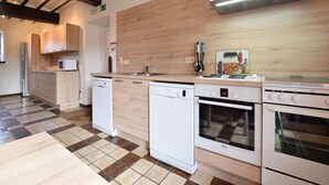 A modern kitchen with white appliances, a wooden backsplash, and a checkered floor. - Luxury Holiday Home with Sauna (Melreux-Hotton)