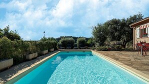 A rectangular swimming pool with clear blue water, surrounded by a stone deck and potted plants. - House in the south of France with private pool (Roquebrun)