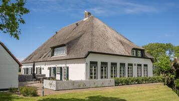 Traditional cottage with a cozy porch and serene surroundings.