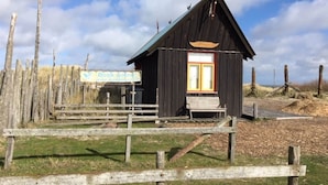 A wooden cabin with a sloped roof and a small porch.