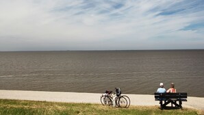 Een bankje aan het water, met fietsen in de buurt.