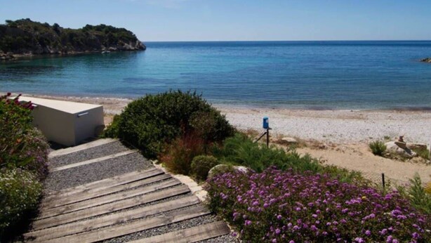 A coastal pathway leading to a beach with a clear view of the sea and a rocky outcrop in the distance. - Belvilla by OYO Apartamento Augusta (Cambrils)