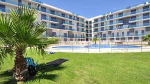 A modern hotel with multiple balconies, a central swimming pool, and a well-maintained lawn. - Belvilla by OYO Apartamento Augusta (Cambrils)
