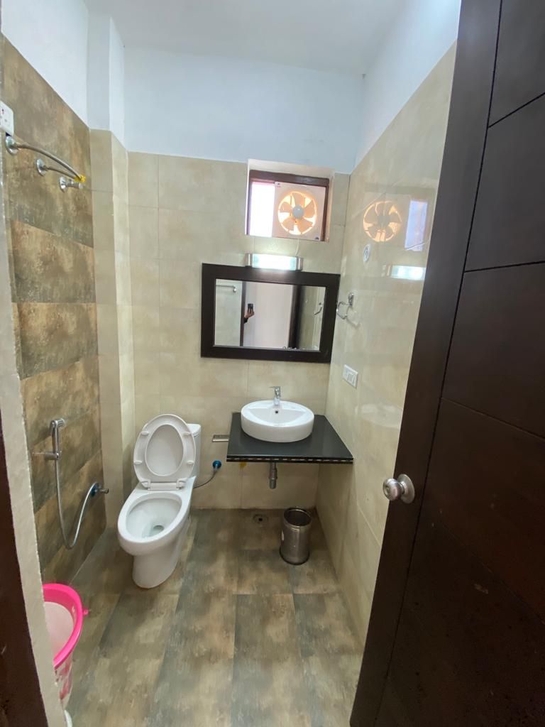 Een kleine badkamer met toilet, wastafel en spiegel.