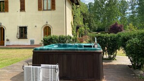 A house with a hot tub, wooden deck, and a garden.