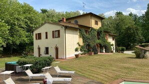 A villa with a pool, lounge chairs, and a well-maintained garden.