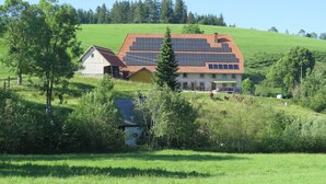 A large house with a red roof and solar panels on the roof.