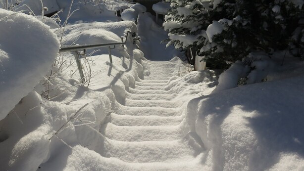 A snow-covered staircase leading up to a building.