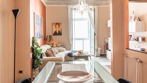 Een gezellige woonkamer met een bank, een bijzettafeltje en een kroonluchter.