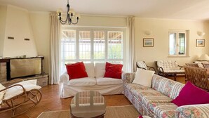 Un salon comprenant un canapé, des fauteuils, une table basse et une cheminée.