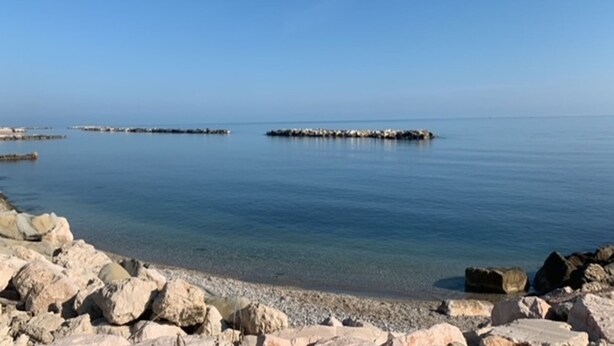 Un rivage rocheux, avec une eau calme et un ciel dégagé.