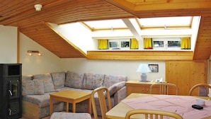 Una stanza accogliente con un letto a soppalco, un divano, un tavolo e una televisione.