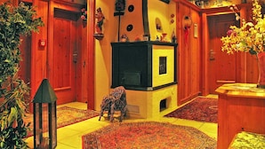 Una stanza accogliente con camino, pareti in legno e un tappeto.