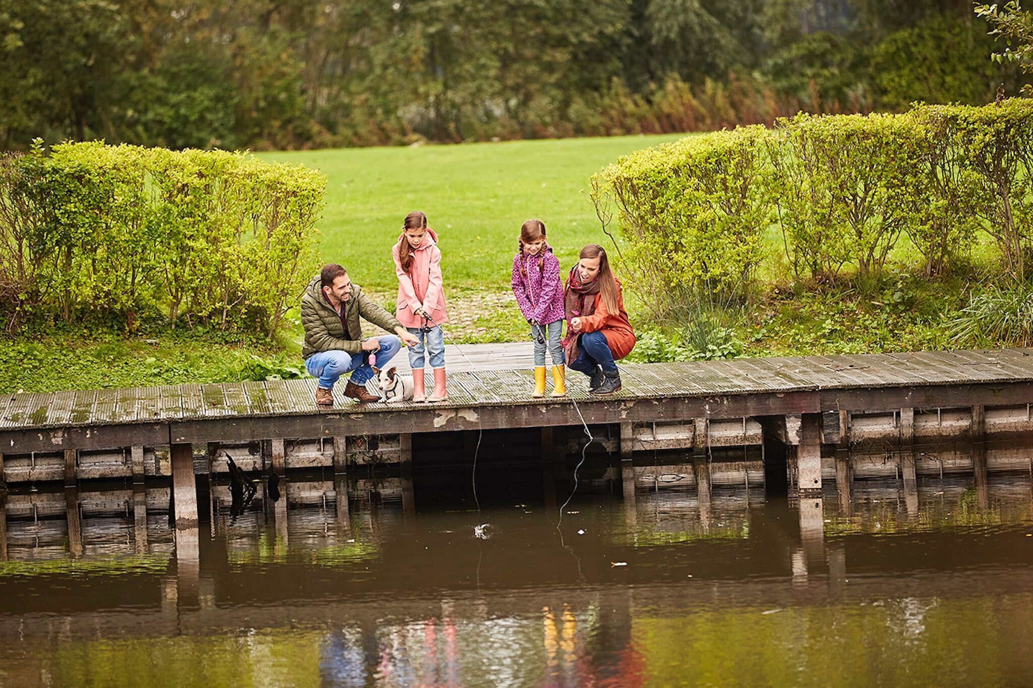 Een houten steiger die zich uitstrekt over het water, met een groep mensen die erop staan.