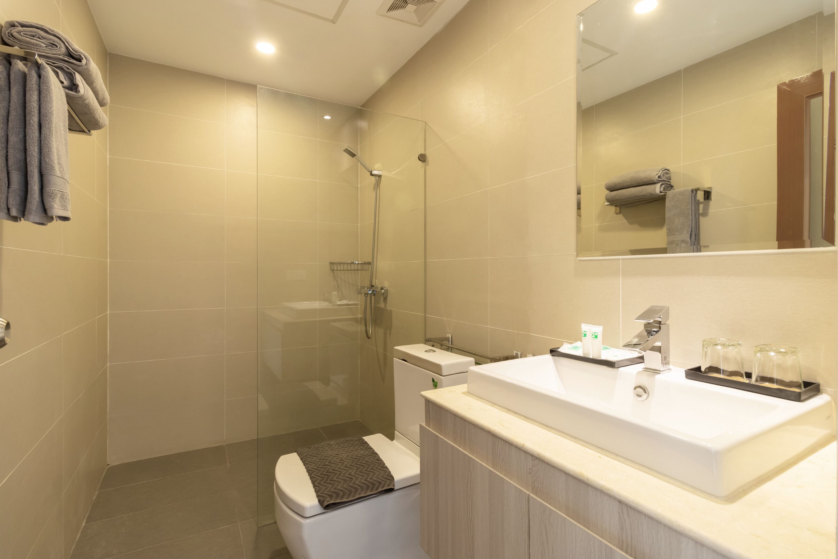 A modern bathroom with a shower, toilet, and sink.