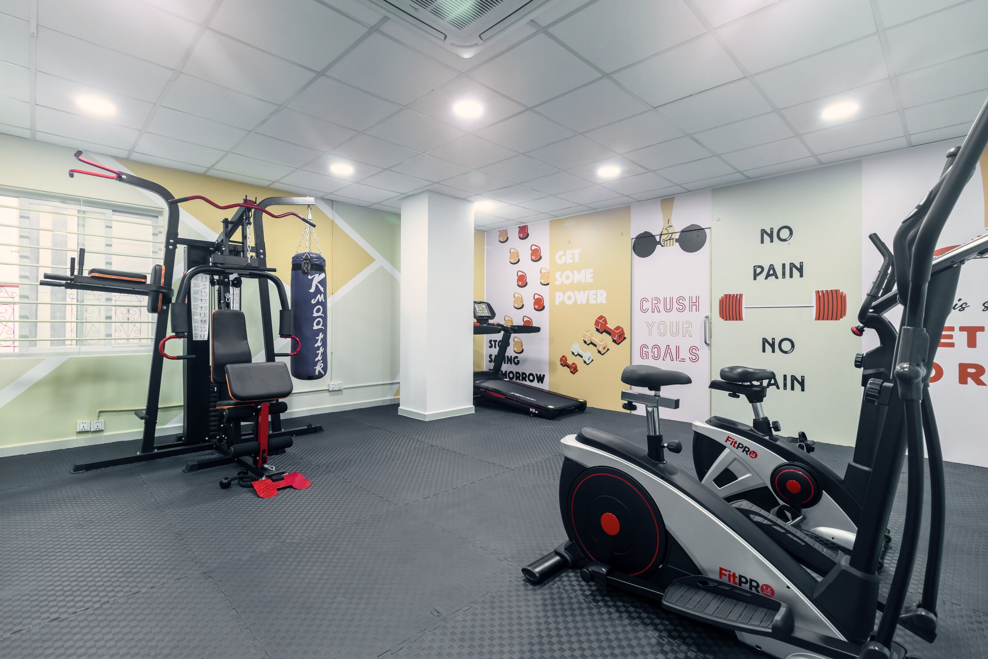 Ein Fitnessstudio mit Cardiogeräten, Kraftmaschinen und motivierenden Wandbildern.