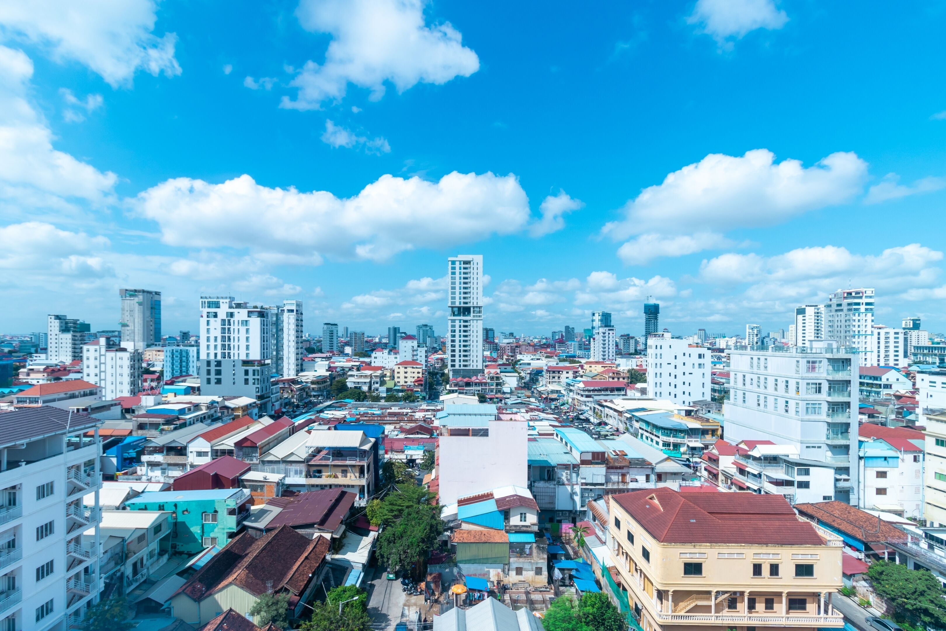 A cityscape with a mix of high-rise and low-rise buildings, a clear blue sky, and a bustling urban environment.