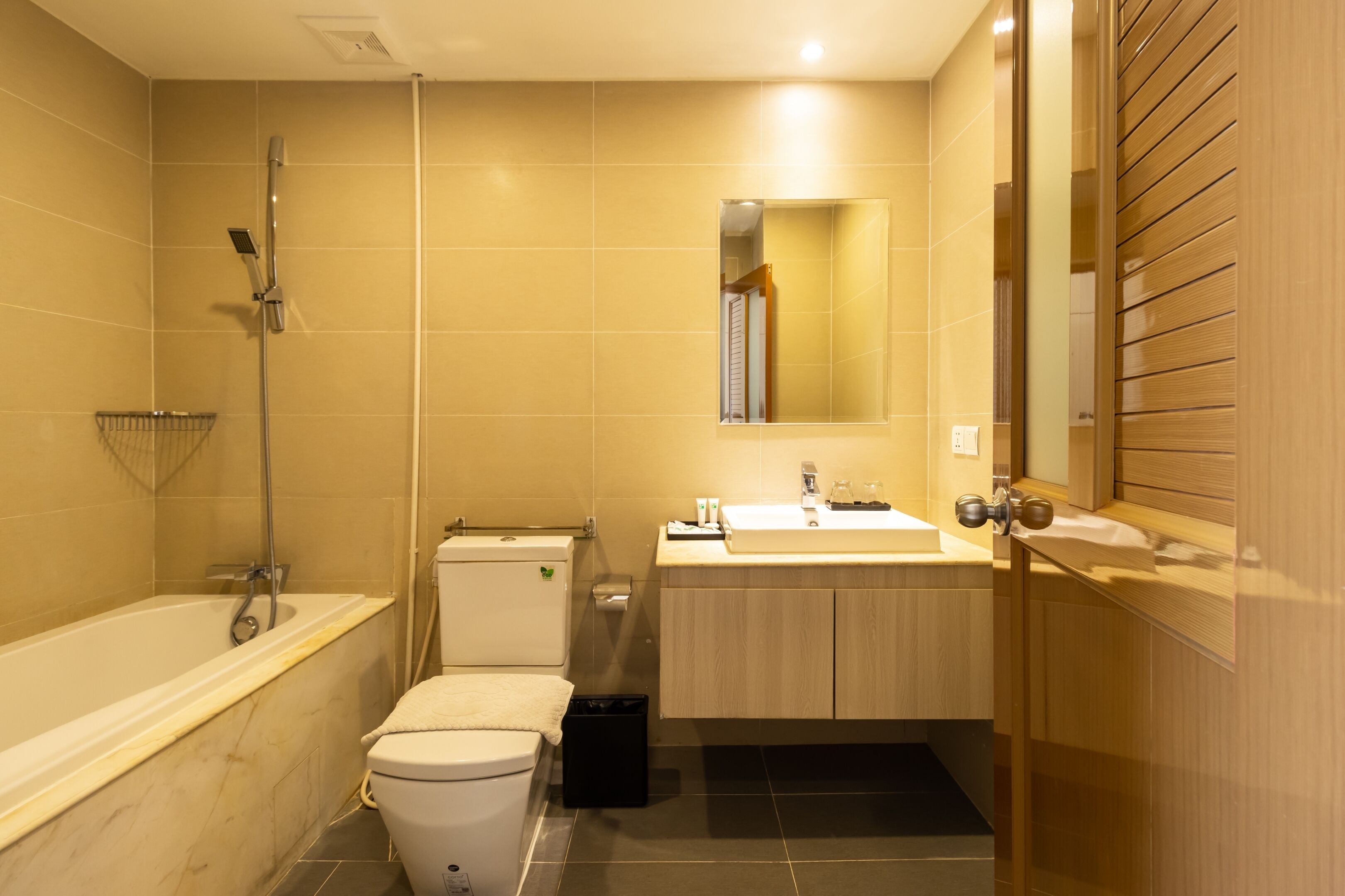 A bathroom with a bathtub, toilet, sink, and mirror.