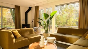 Una sala de estar moderna con dos sofás, una mesa de centro, una planta en maceta y una chimenea.