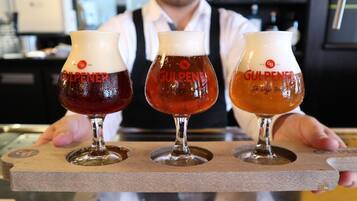 Drie glazen bier op een houten dienblad.