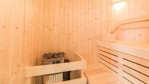 A wooden sauna with benches and a stone heating element. - Modern Retreat in Maastricht (Maastricht)