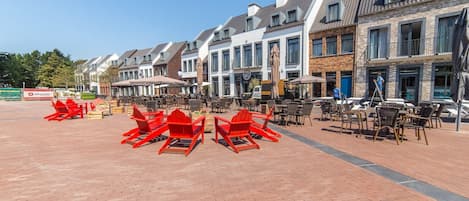Una hilera de edificios de estilo tradicional europeo con terrazas al aire libre.