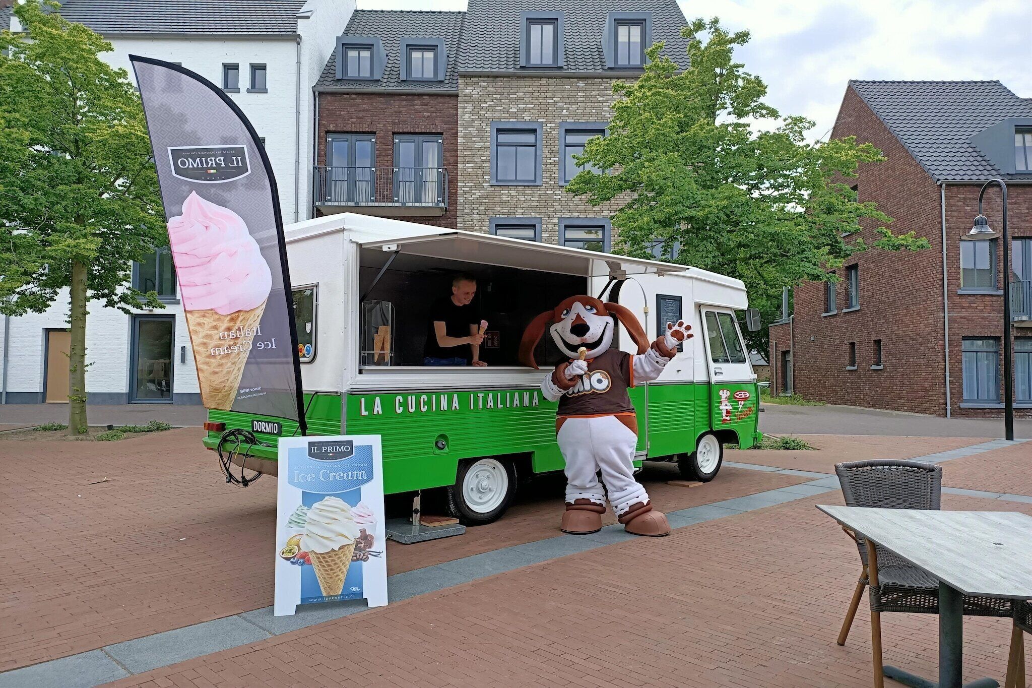 Een foodtruck met een persoon in een hondenkostuum er naast.