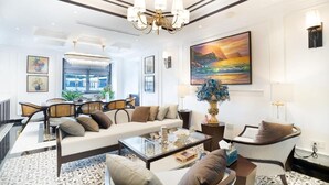 A spacious living room with a sofa, armchairs, a coffee table, and a chandelier. - Maison d'Rose (Phu Quoc)