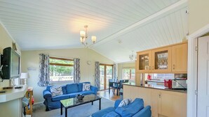 A spacious living room with a sofa set, a coffee table, and a television.