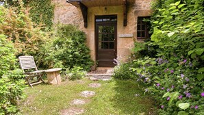 Un bâtiment en pierre avec une porte en bois et des marches menant à l’entrée.