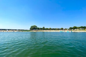 A beach with boats, a sandy shore, and a clear blue sky. - Modern chalet with a dishwasher in Lathum (Lathum)