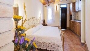 A bedroom with a wooden ceiling, a bed with a white bedspread, a small table, and a chair. - Relaxing Retreat in Le Marche (Monte San Martino)
