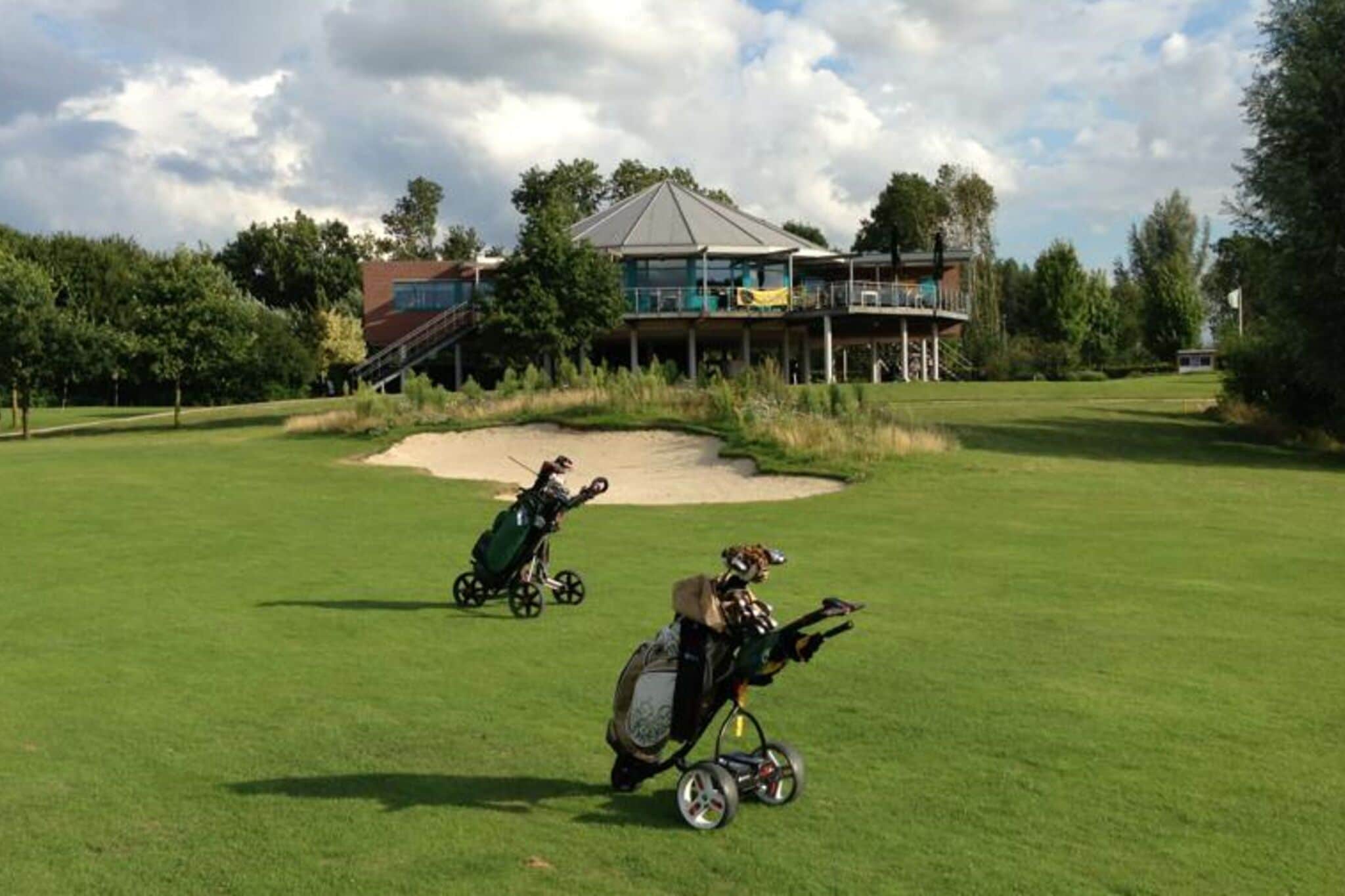 Un campo de golf con un club de campo y un búnker de arena.