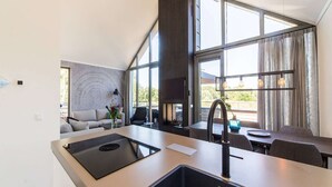 Eine moderne Küche mit einer großen Kochinsel, einem Essbereich mit Tisch und Stühlen sowie einer Sitzecke mit Sofa und Couchtisch.