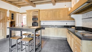 Una cocina moderna con armarios de madera, una isla central y una encimera negra.