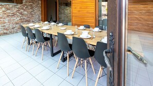 Un comedor con una larga mesa dispuesta para una comida, rodeada de sillas.