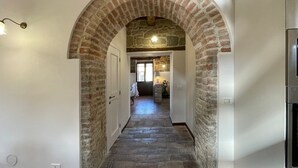 A hallway with a stone archway, a refrigerator, and a lamp. - Large Group Retreat with Pool (Amandola)