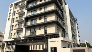 Un immeuble à plusieurs étages, doté d’une façade sobre, de balcons et d’une entrée fermée par un portail.