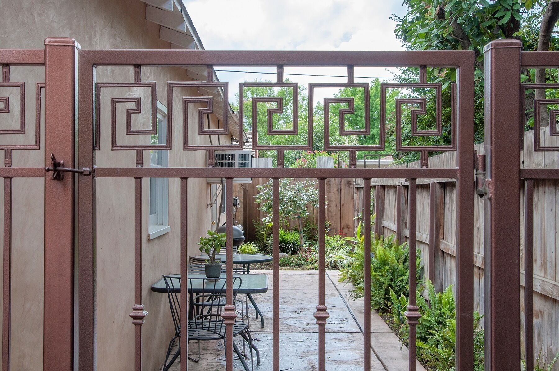 Un patio trasero cercado con una mesa y sillas.