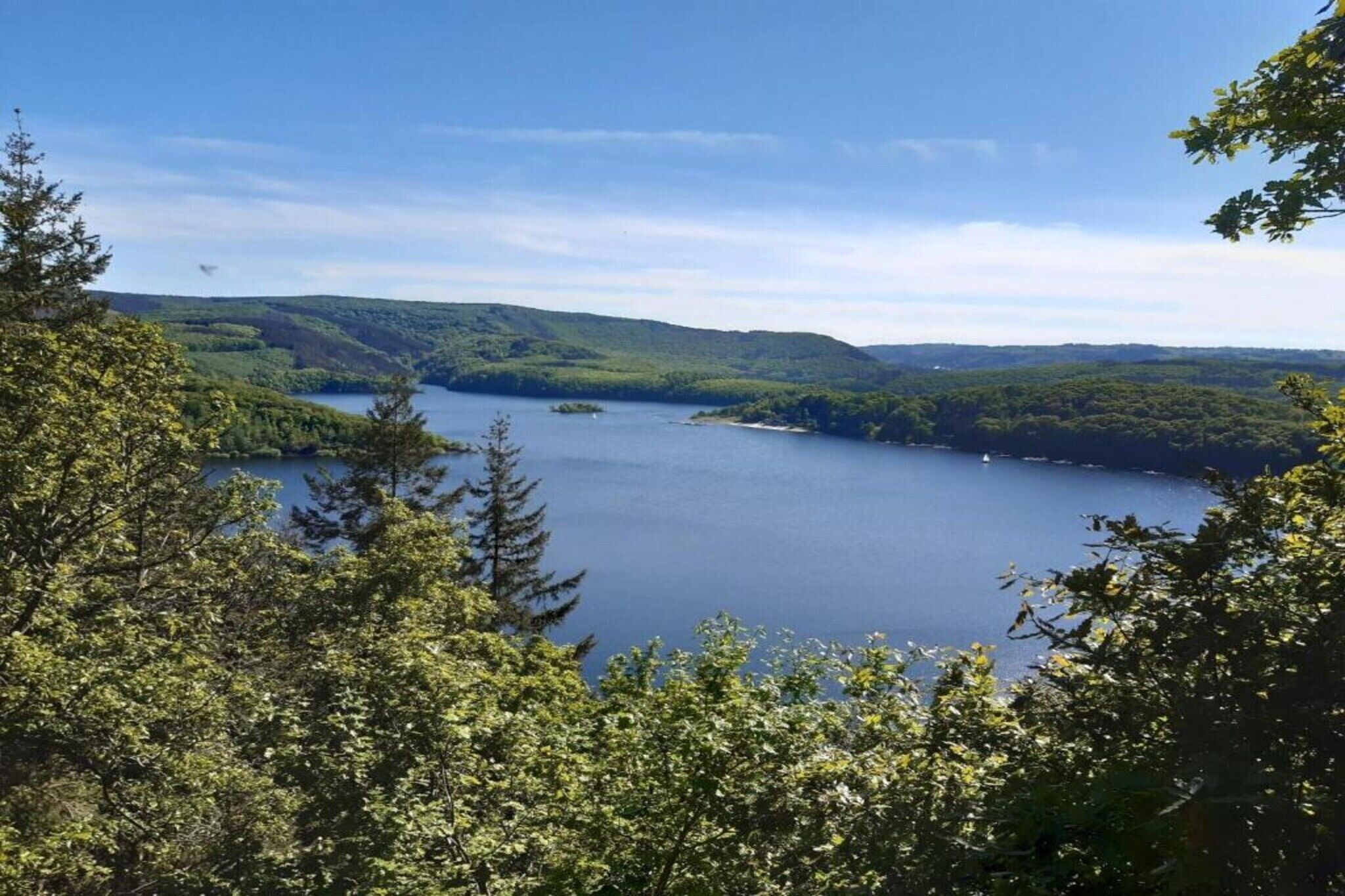 Un lac entouré de collines boisées.