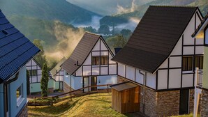 A traditional half-timbered house with a stone foundation, a wooden door, and a visible chimney. - Modern penthouse with Rur valley view (Heimbach)