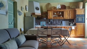 Una sala acogedora con sofá y comedor con mesa y sillas.