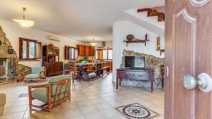 Un amplio salón con chimenea, muebles de madera y una pared de acento de piedra.